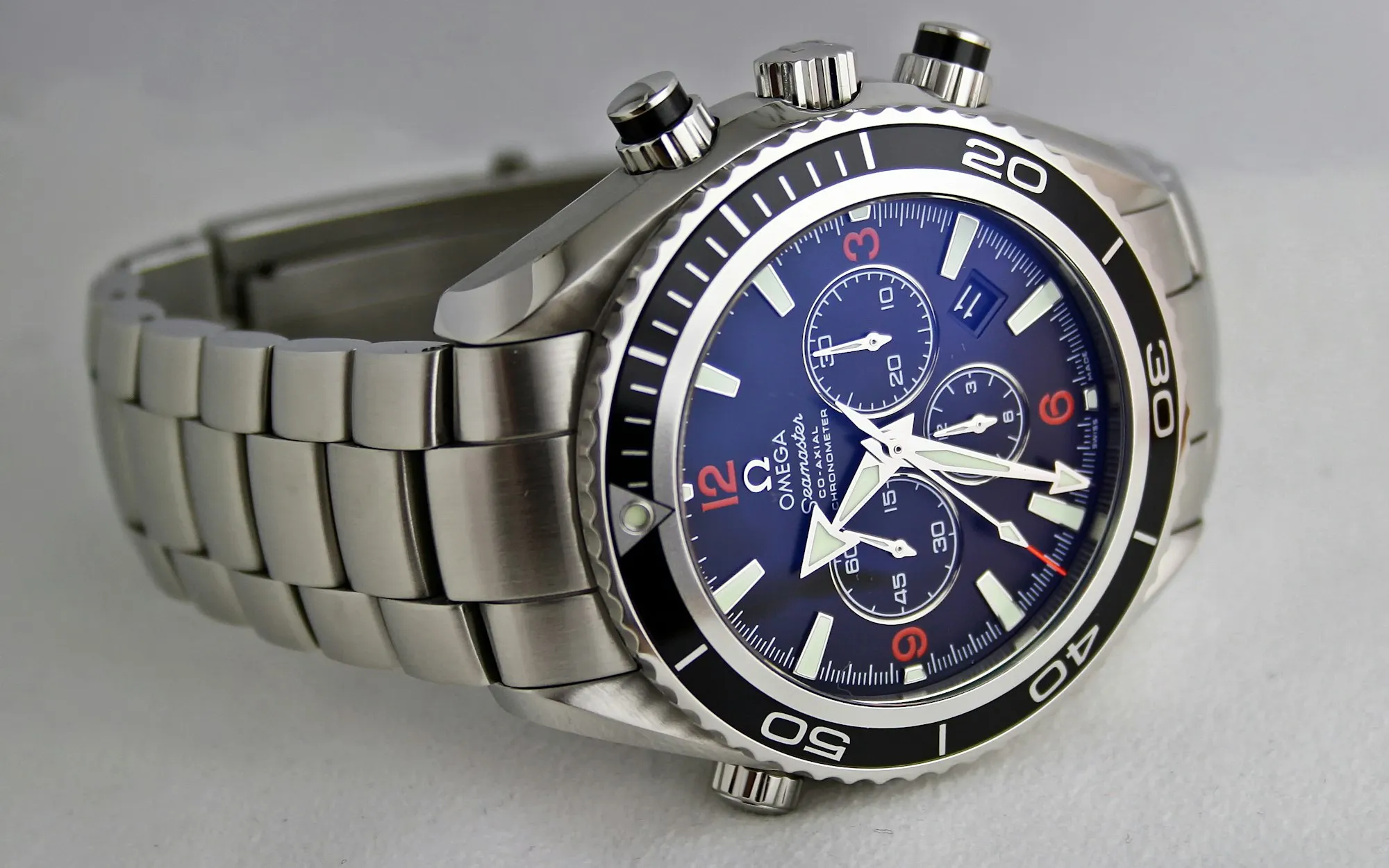 A mechanical wristwatch on a dark surface