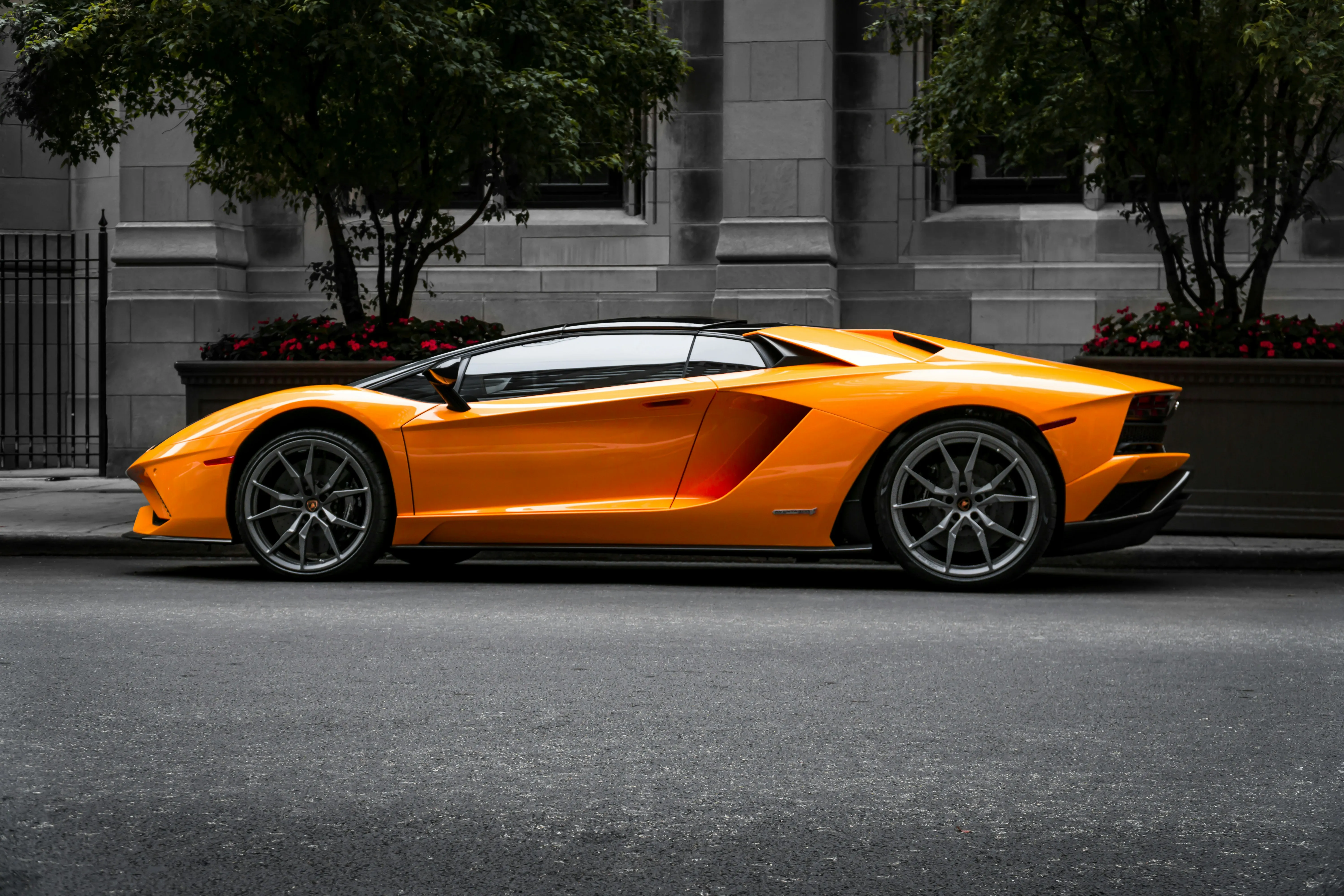 An orange sports car parked on a city roadway