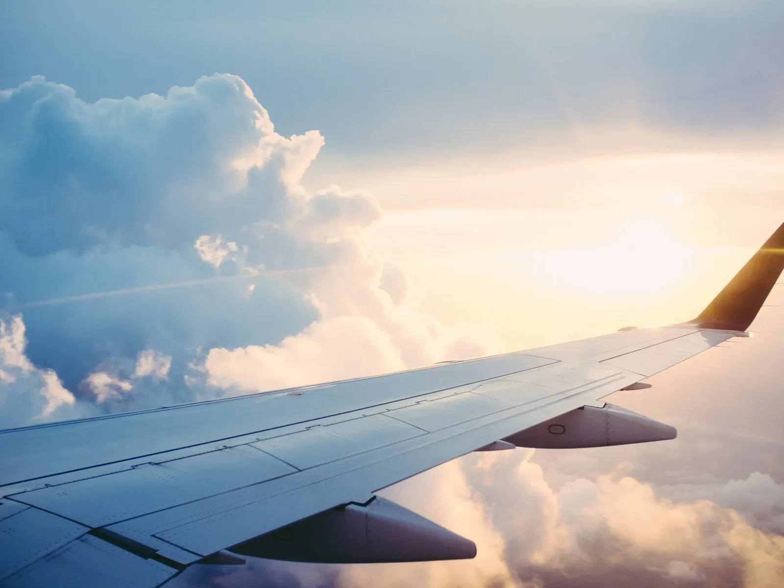 An aircraft wing above a calm layer of clouds